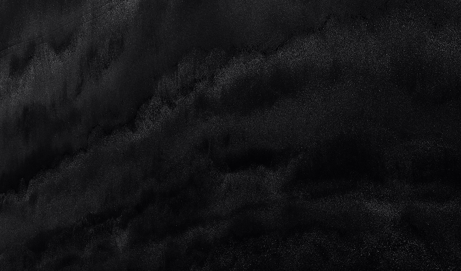 Abstract black texture with subtle gradient effects.